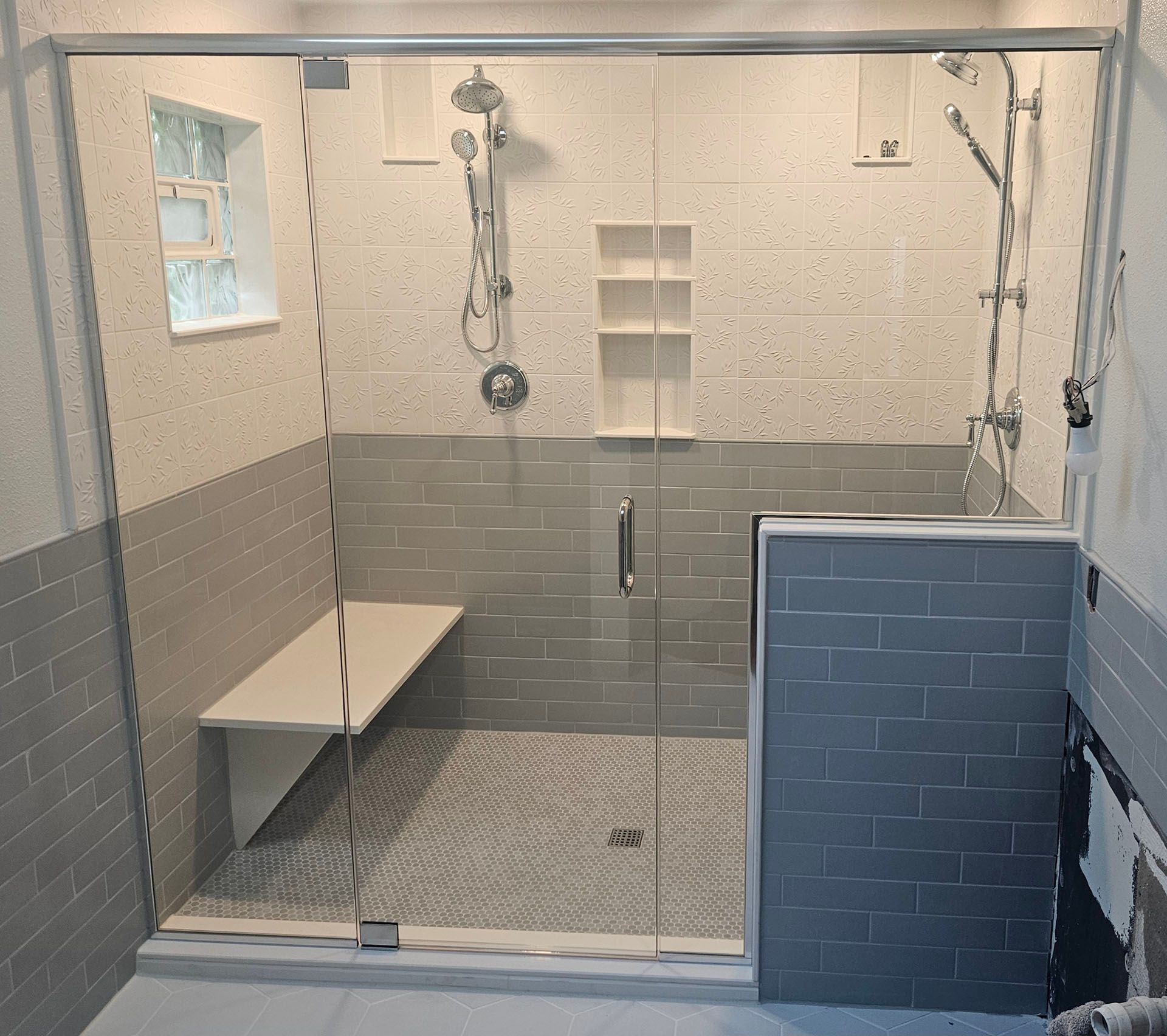 Multiple panels - A bathroom with a sliding glass shower door and a bench.