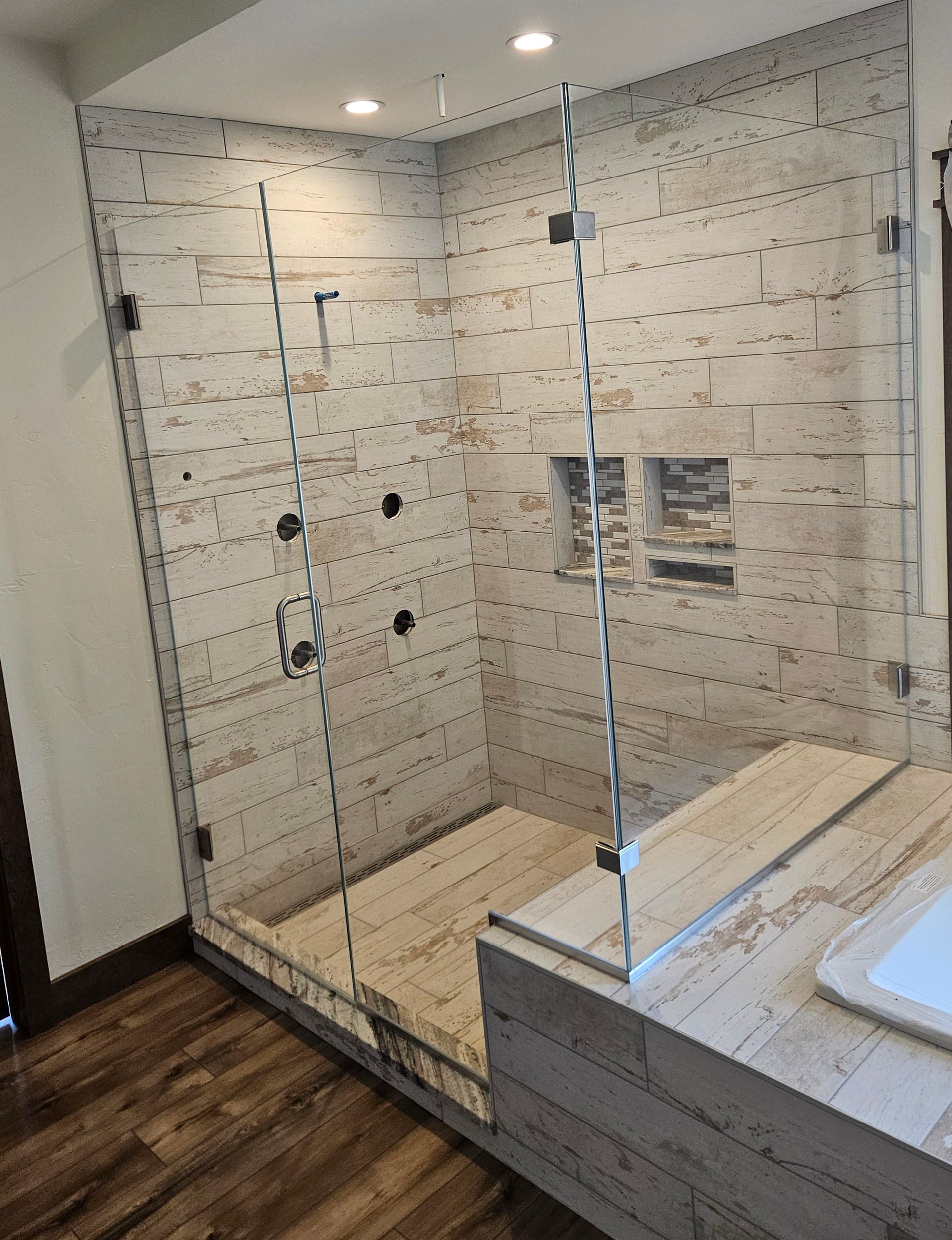 Return panel - A bathroom with a walk in shower and a sink.