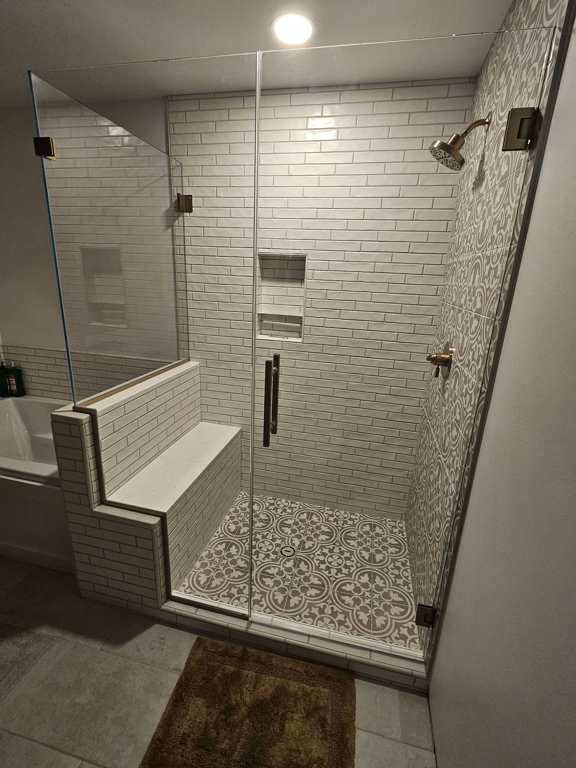 Return panel - A bathroom with a walk in shower with a glass door.