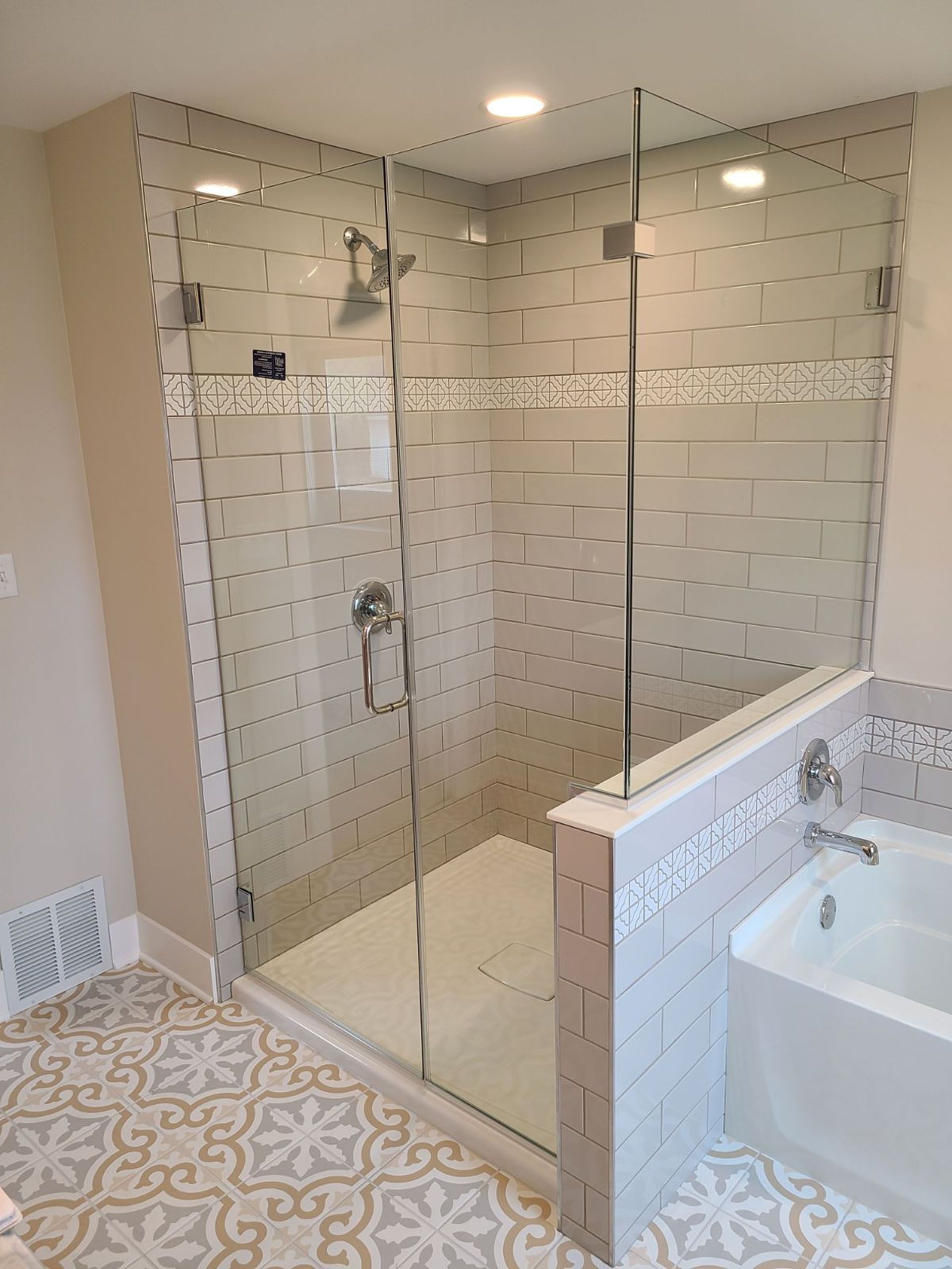 Return panel - A bathroom with a walk-in shower and a bathtub.