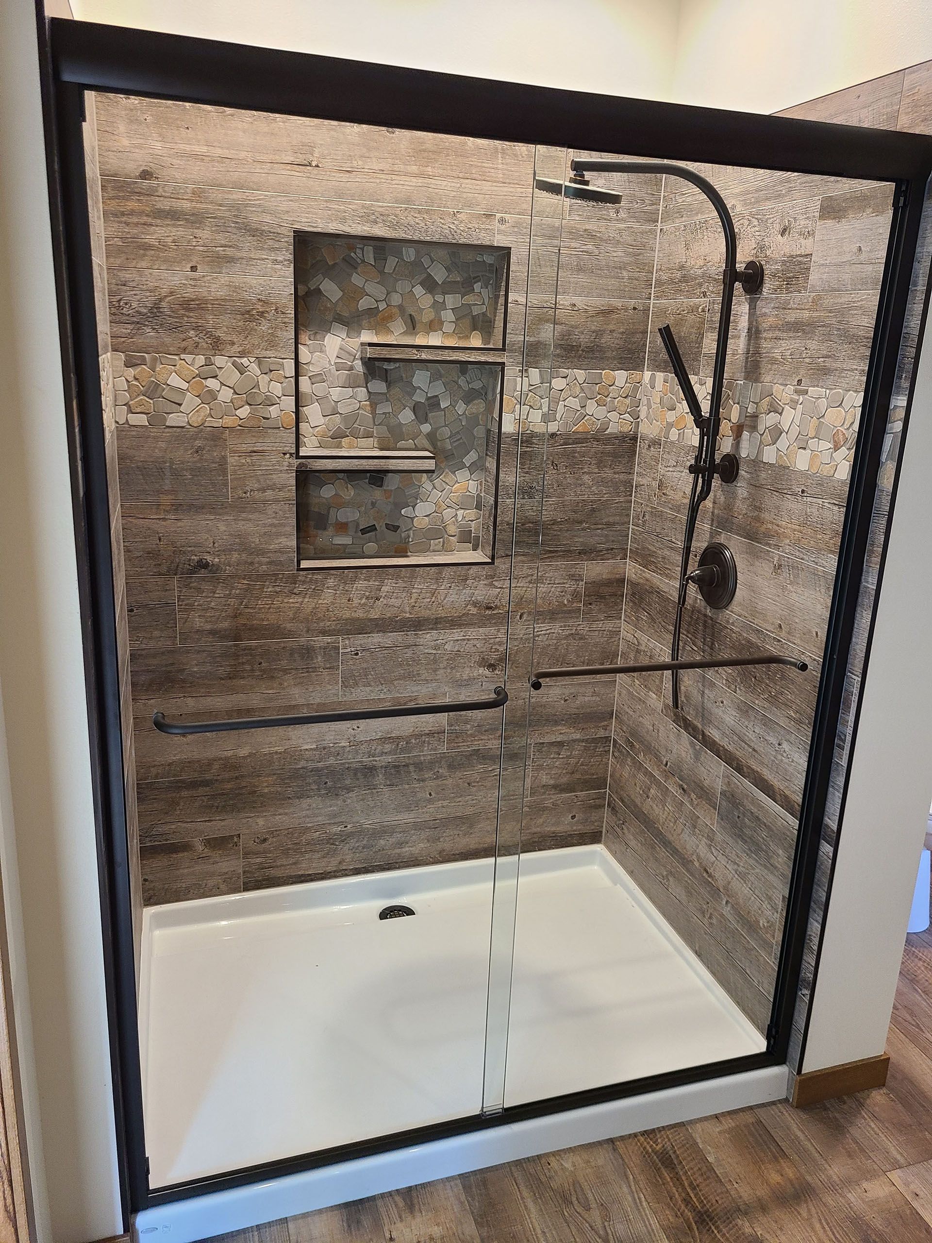 Sliding glass - A bathroom with a walk-in shower with a sliding glass door.