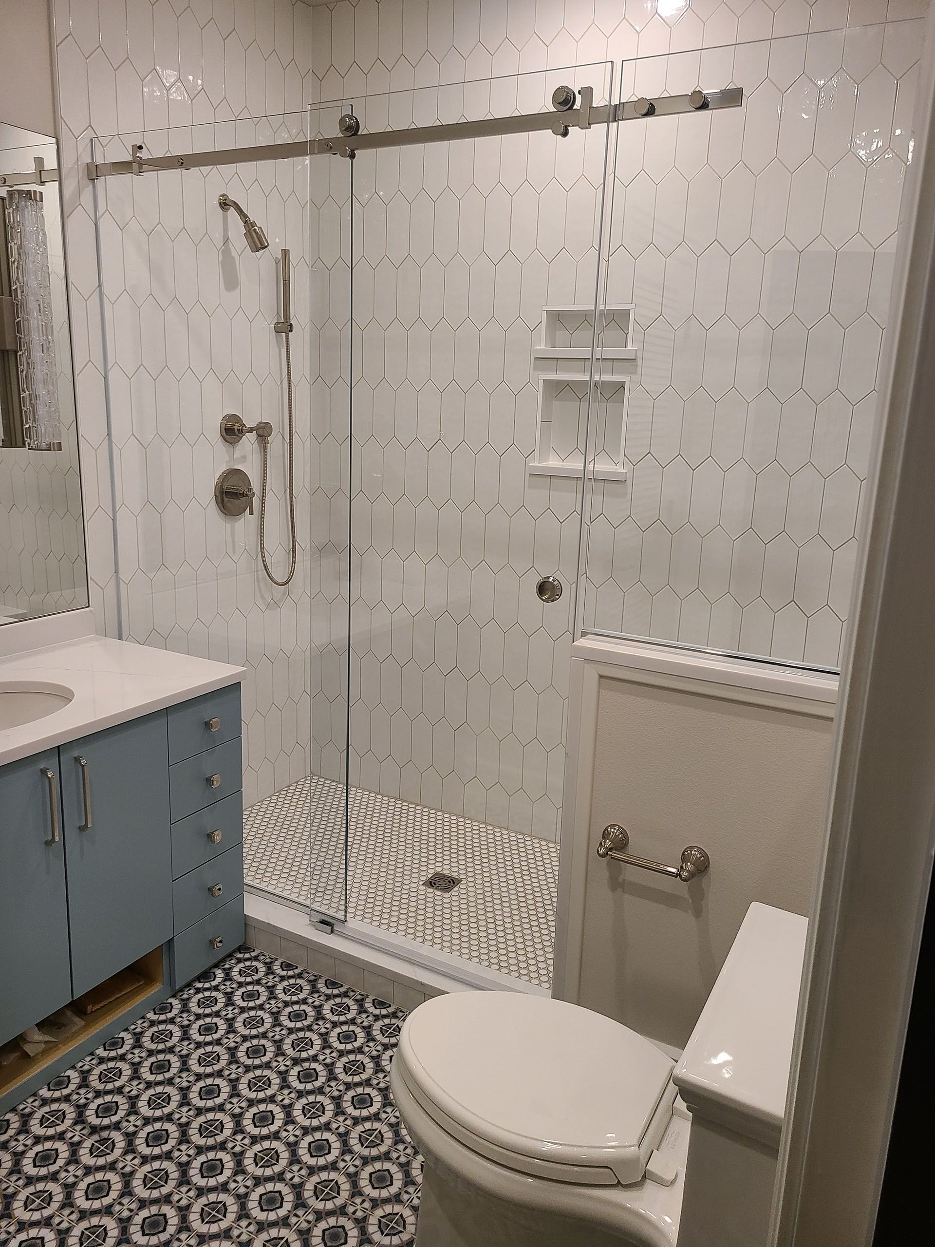 Sliding glass - A bathroom with a toilet, sink, shower, and sliding glass door.