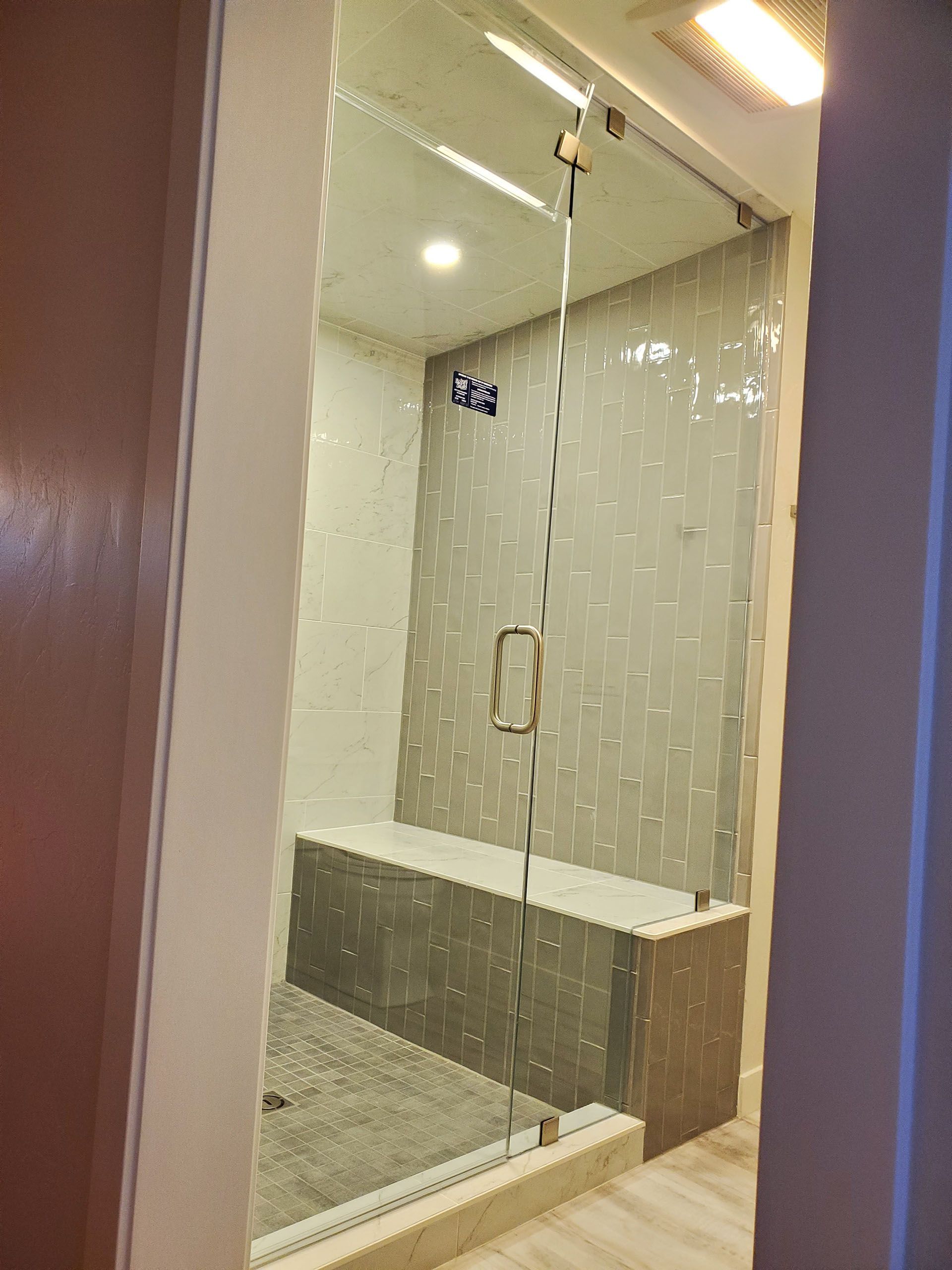 Steam showers - A bathroom with a walk-in shower with a glass door.