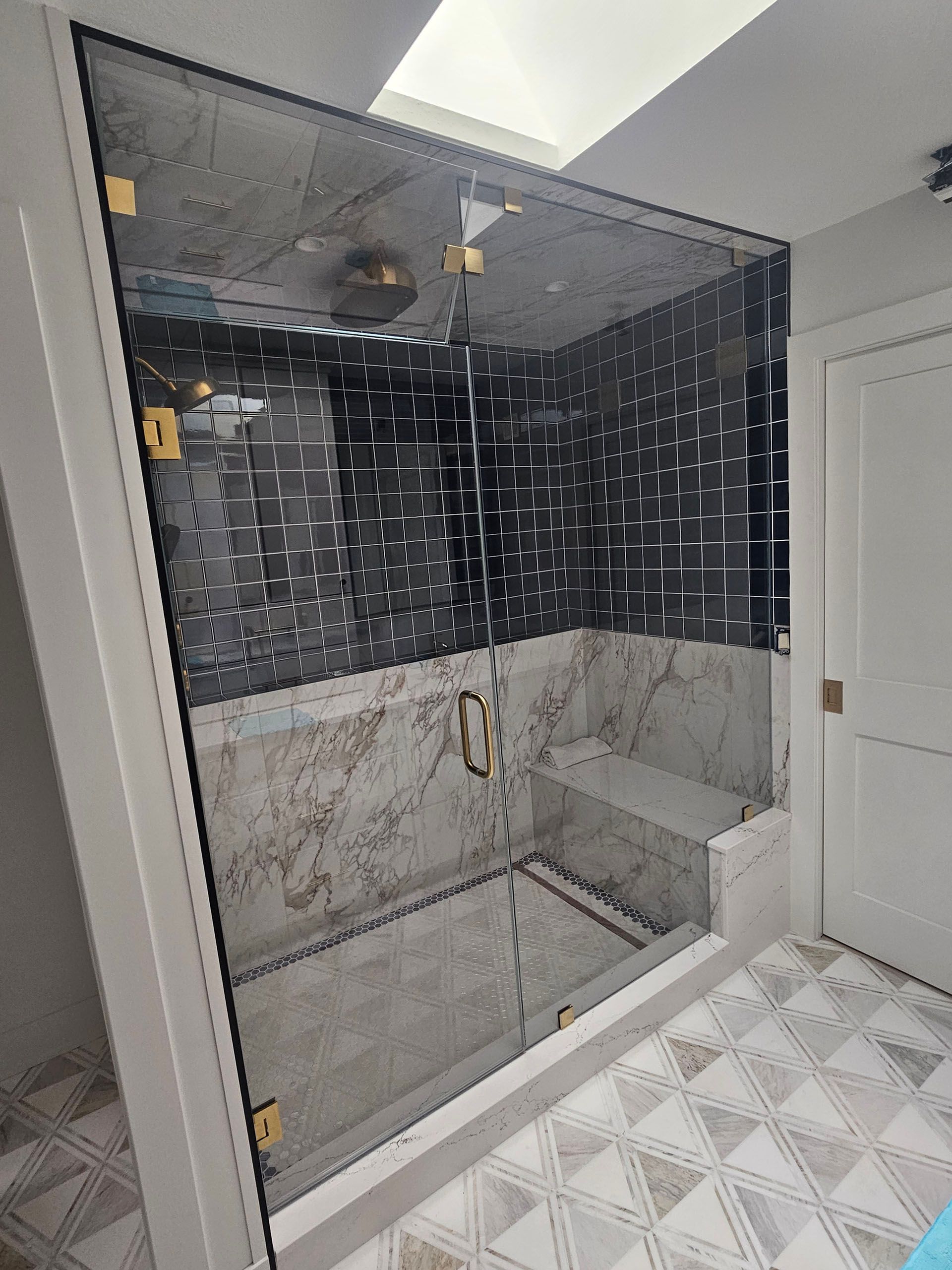 Steam showers - A bathroom with a walk-in shower with a glass door.