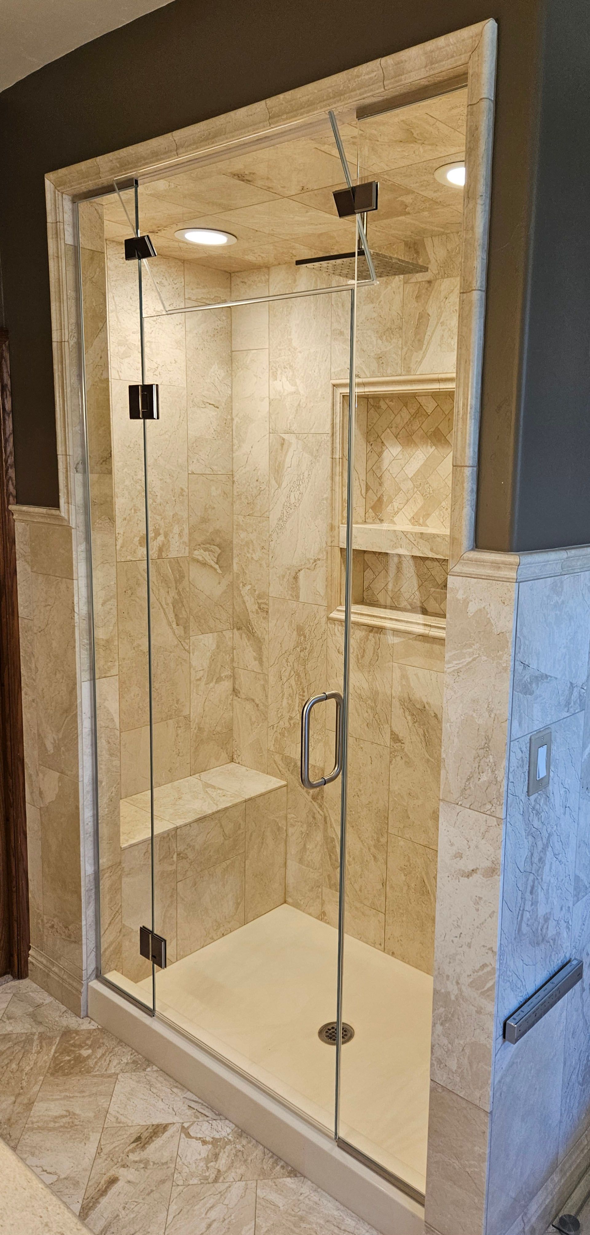 Steam showers - A bathroom with a walk-in shower with a glass door.