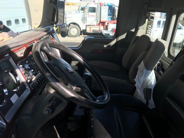 The inside of a truck with a steering wheel and seats.
