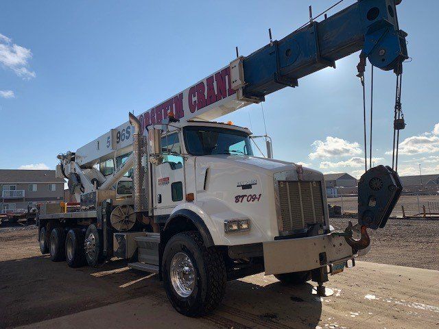 A white truck with a crane attached to it and the word crane on the side