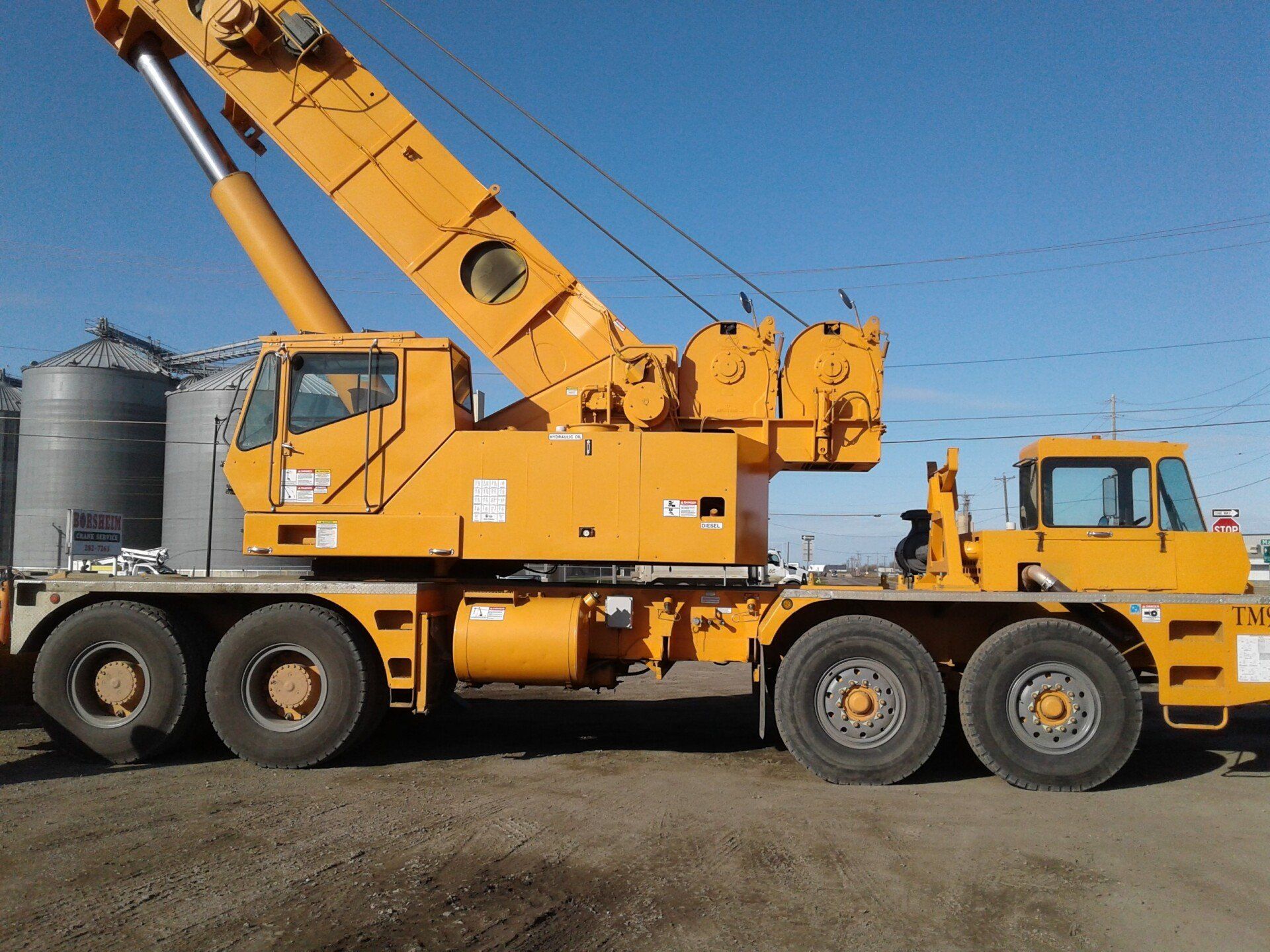 A large yellow truck with a crane on top of it