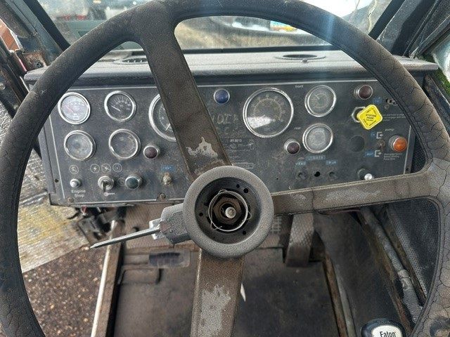 A close up of a steering wheel and dashboard of an old vehicle