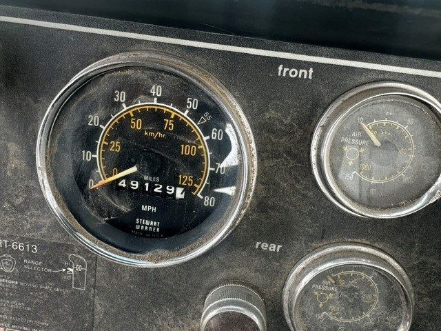 A close up of a dashboard with a speedometer that reads 4912