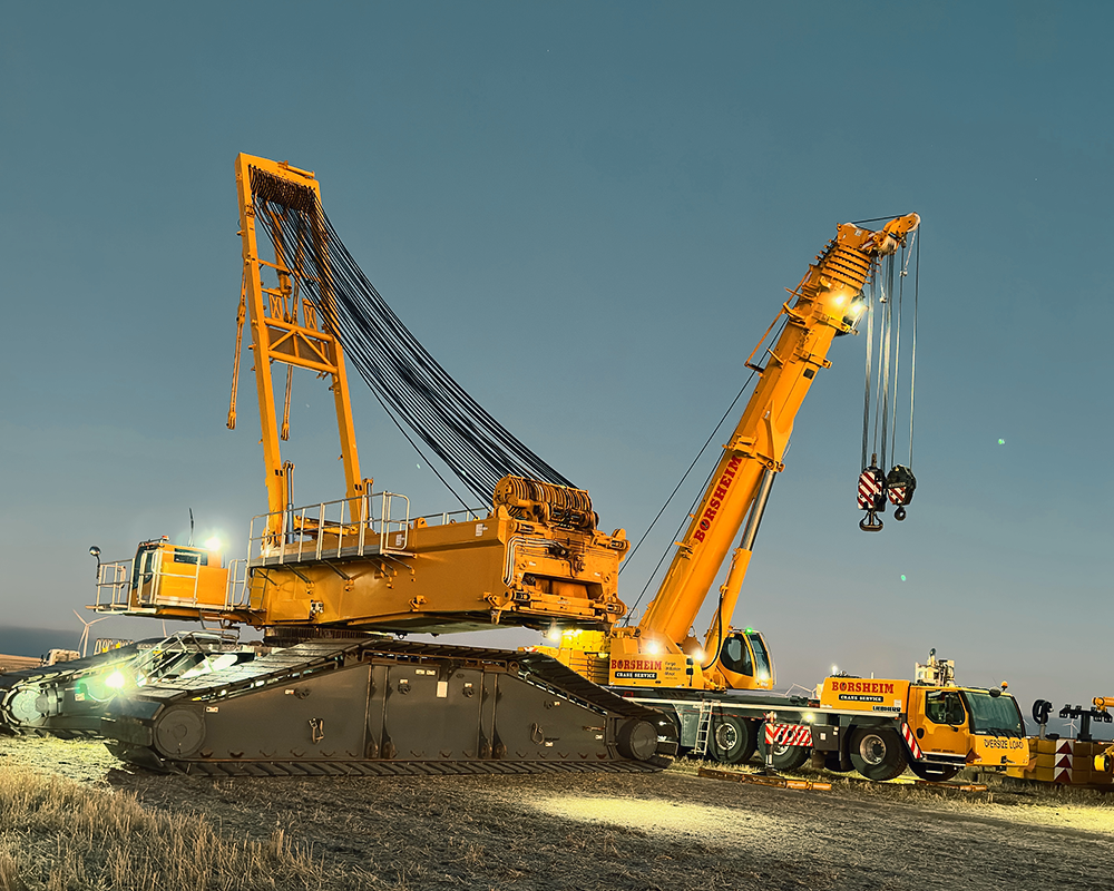 A large yellow crane is parked on the side of the road