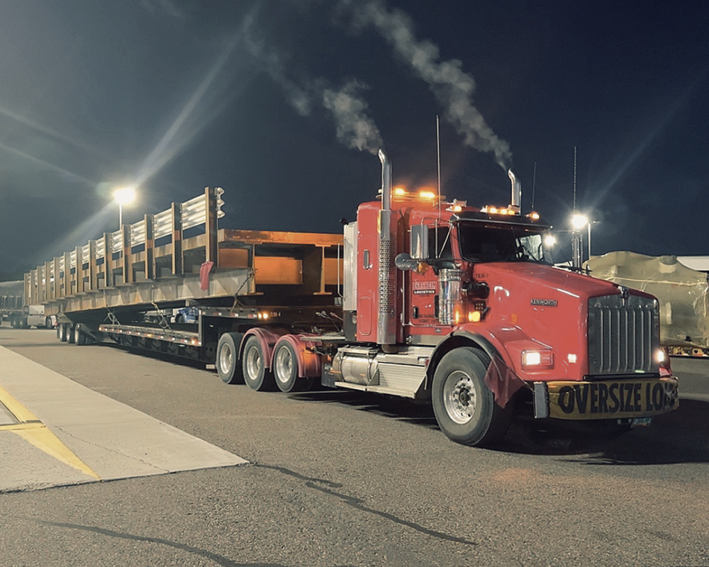 A red semi truck with the word oversize on the side