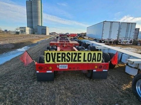 A trailer with a sign on the back that says `` oversized load ''.