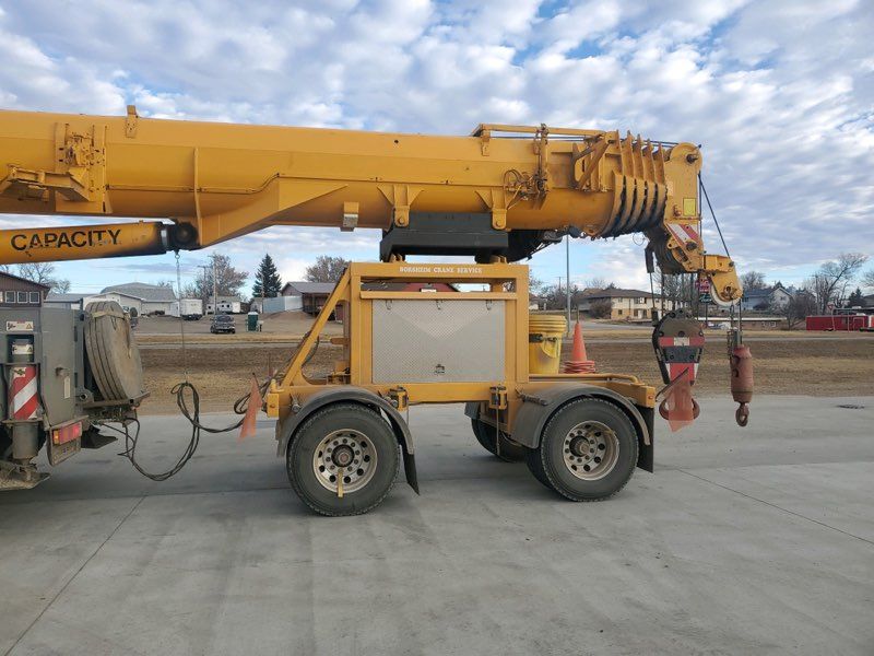 A yellow crane is parked on the side of the road.