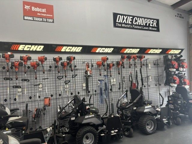 A retail store wall displaying Echo outdoor power equipment and two zero turn mowers under Bobcat and Dixie Chopper signs. 