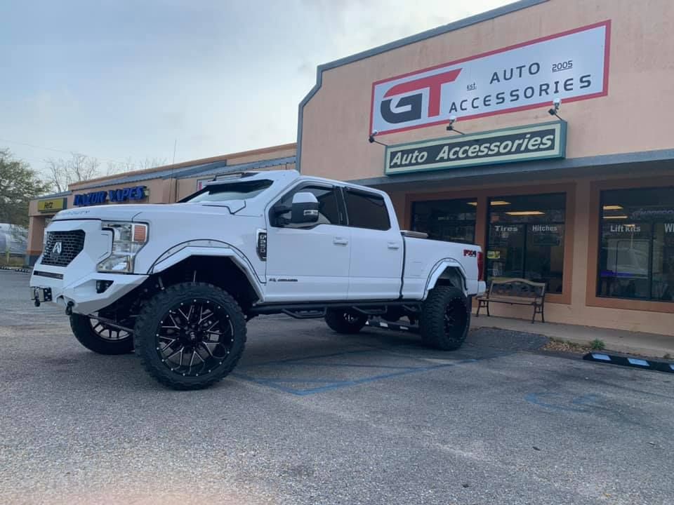 A white truck is parked in front of a building.