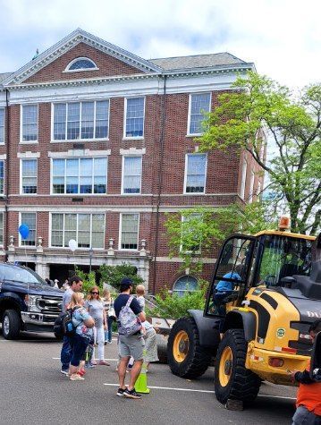 A group of people are standing in front of a large brick building.