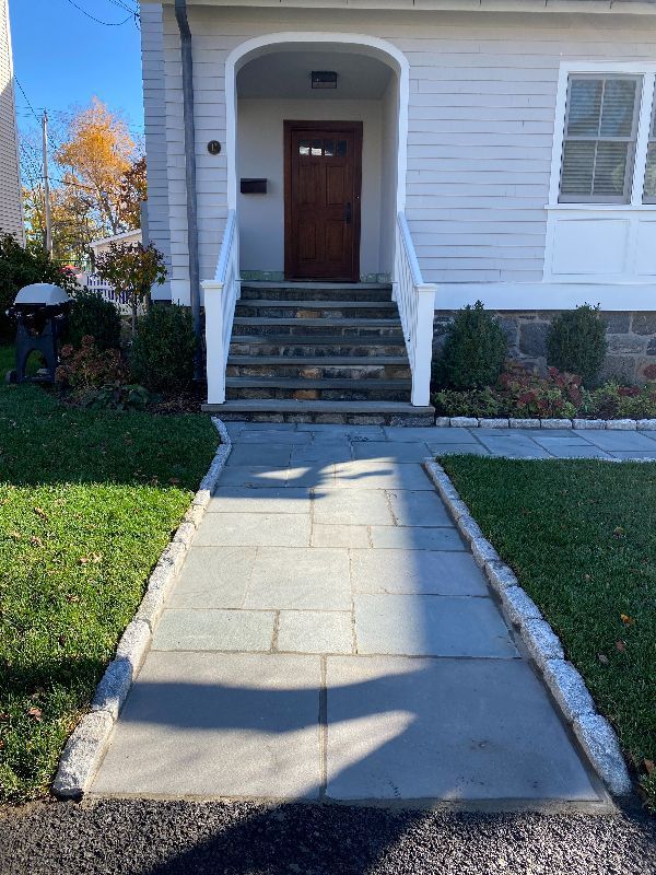 A stone walkway leading to the front door of a house.