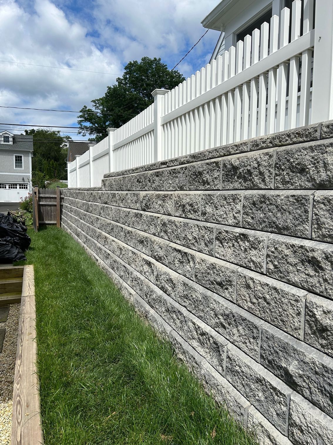 A large brick wall with a white fence surrounding it.