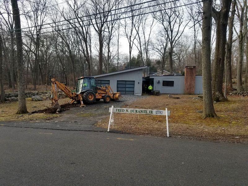 A construction vehicle is parked in front of a house.