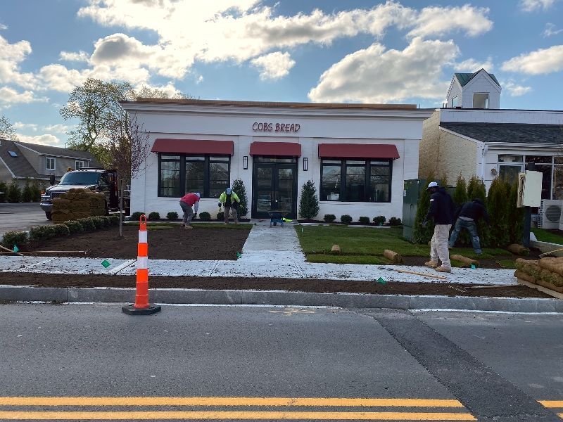 A white building with a red awning is being remodeled