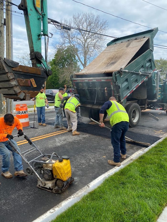 A group of construction workers are working on a road.