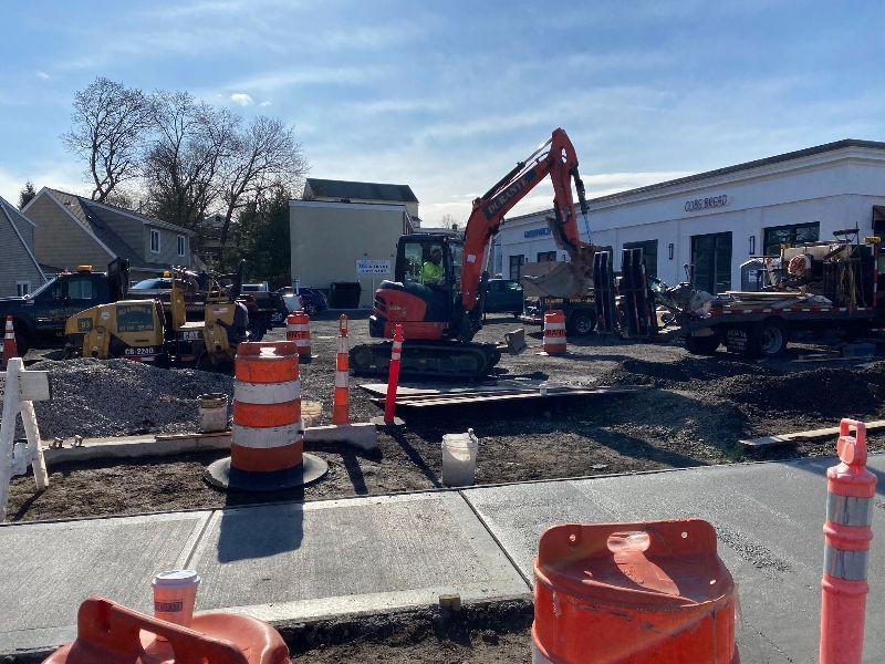 A construction site with a lot of machinery and cones.