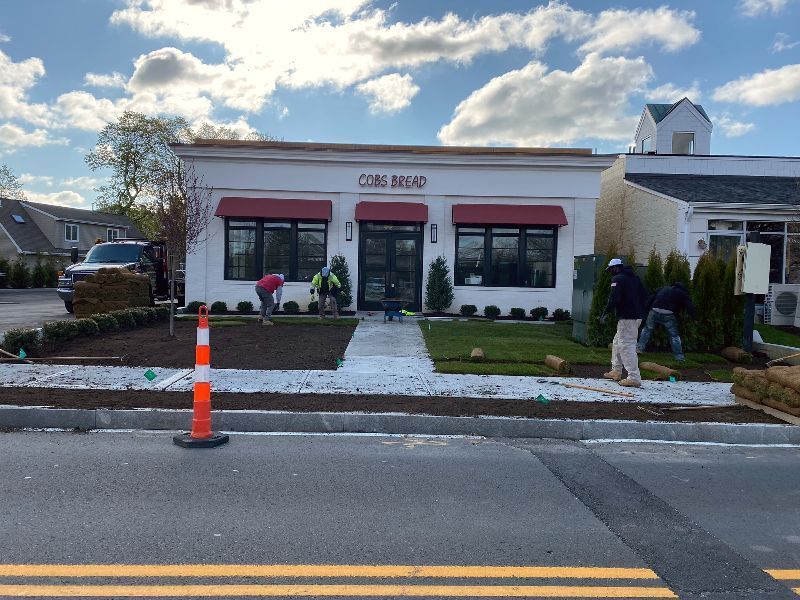 A white building with a red awning is being remodeled.