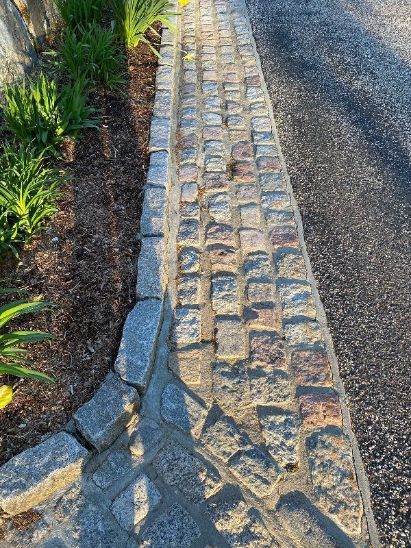 A stone walkway along the side of a road.