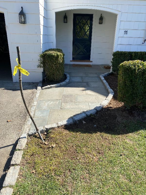 A stone walkway leading to the front door of a house.