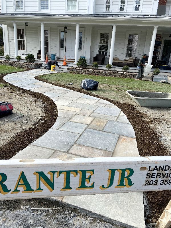 A stone walkway is being built in front of a house.