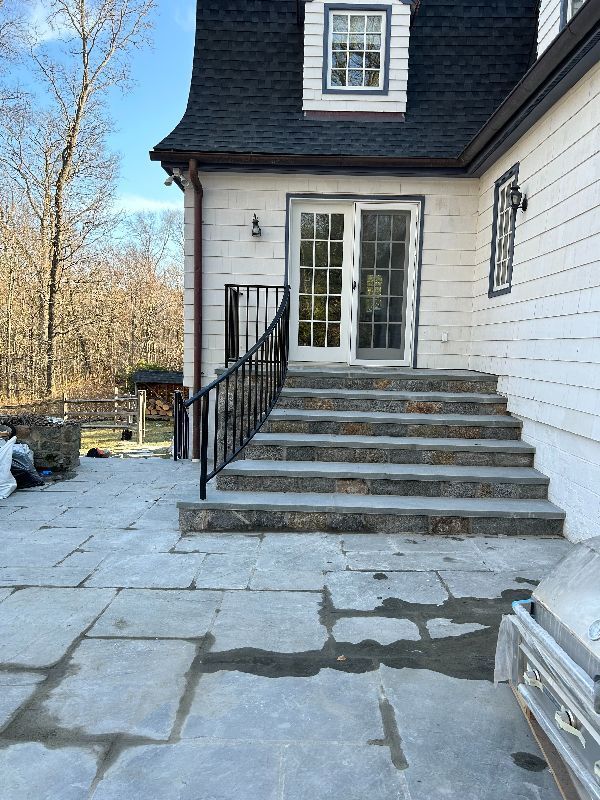 A white house with stairs leading up to the front door