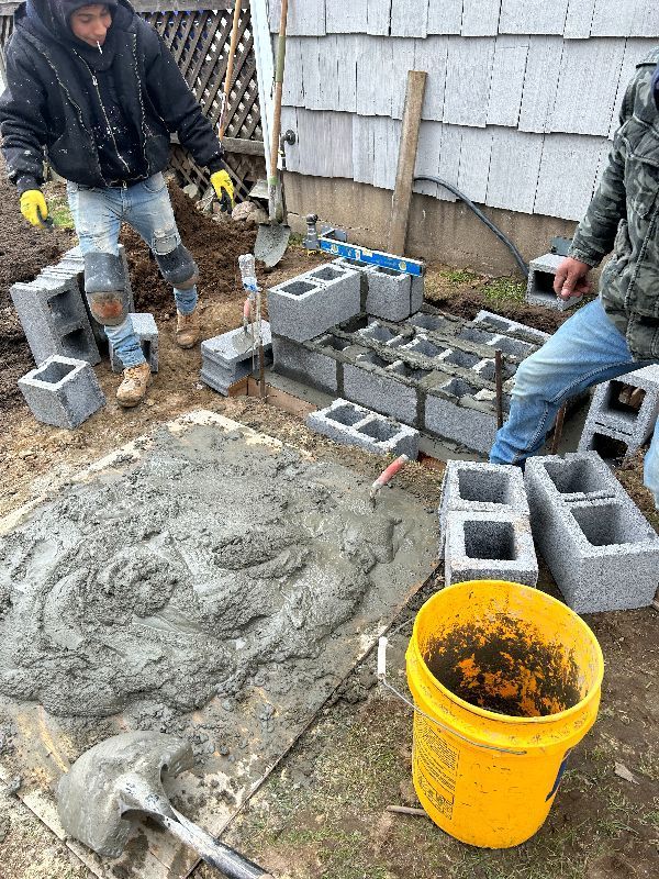 Two men are working on a concrete project in a backyard.