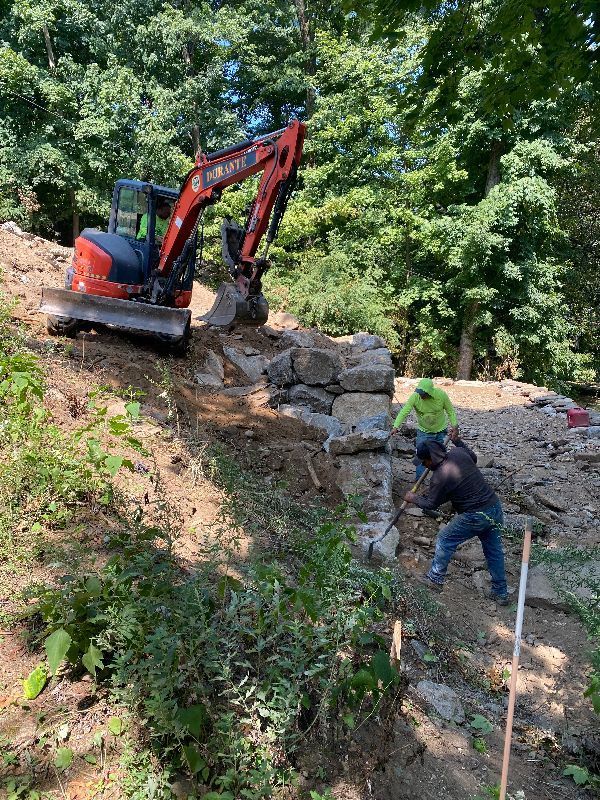 A man is digging in the dirt next to a bulldozer.