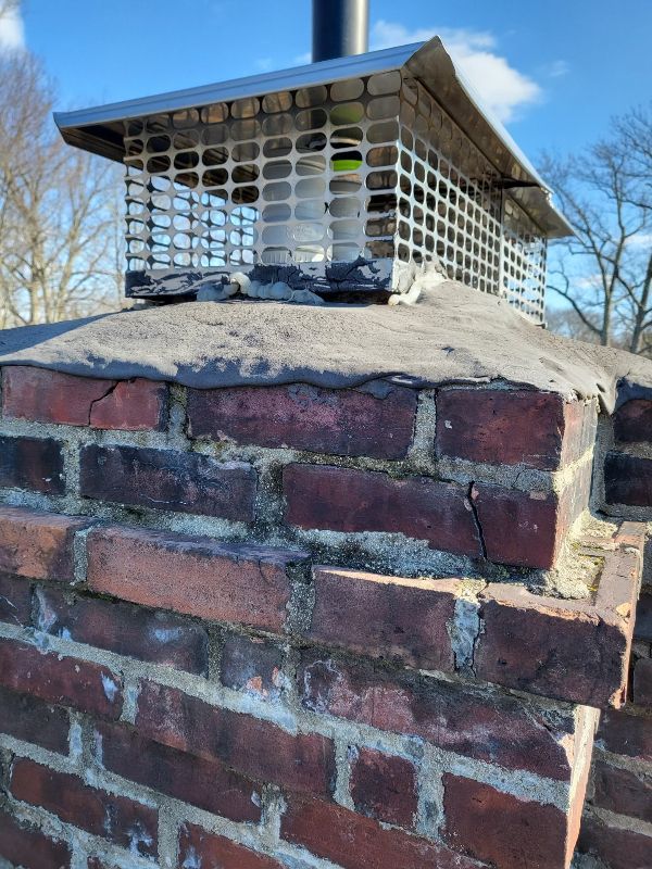 A chimney is sitting on top of a brick wall.