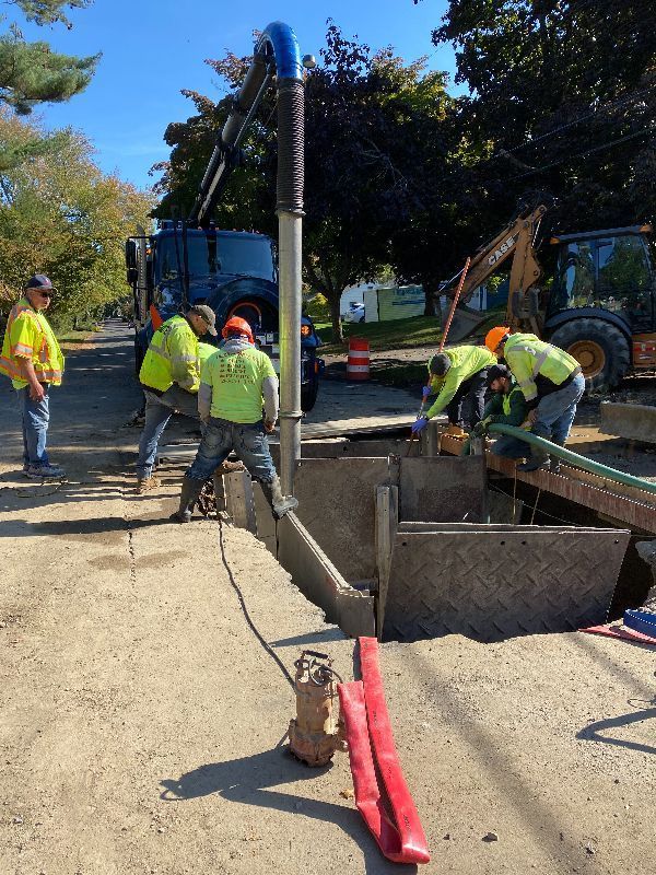 A group of construction workers are working on a hole in the ground