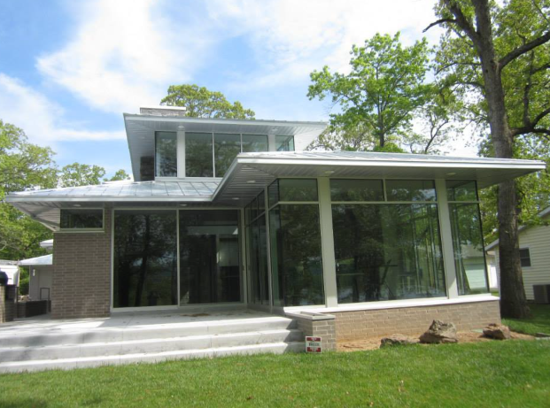 A house with a lot of windows and trees in the background