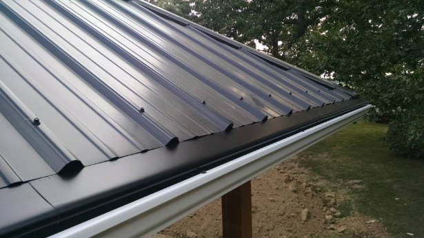 A close up of a black metal roof with a white gutter.