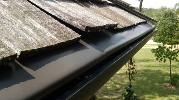 A close up of a gutter on the side of a roof.