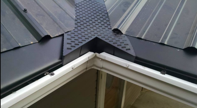 A black roof with a white gutter on the side of it
