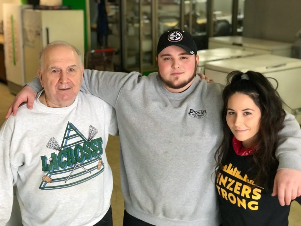 A man and two women are posing for a picture in a store.