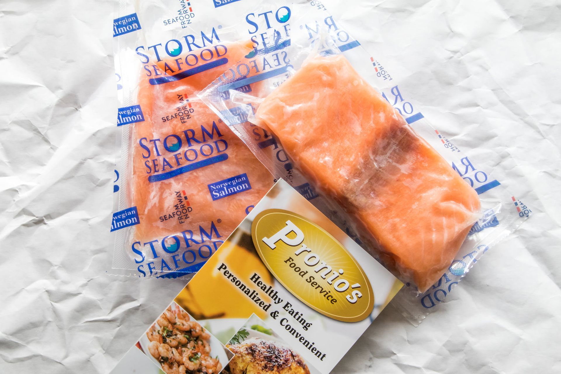 Two pieces of salmon are sitting next to each other on a piece of paper.