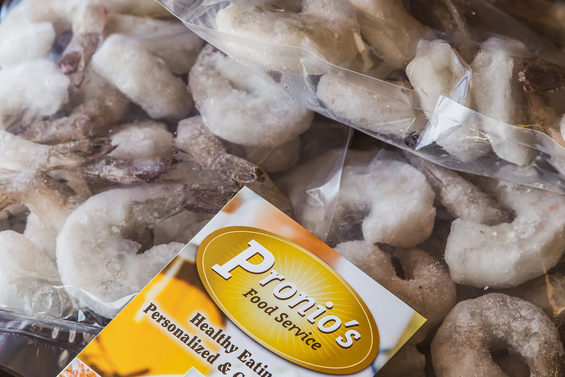 A bag of shrimp sits next to a bag of shrimp from pronto 's food service