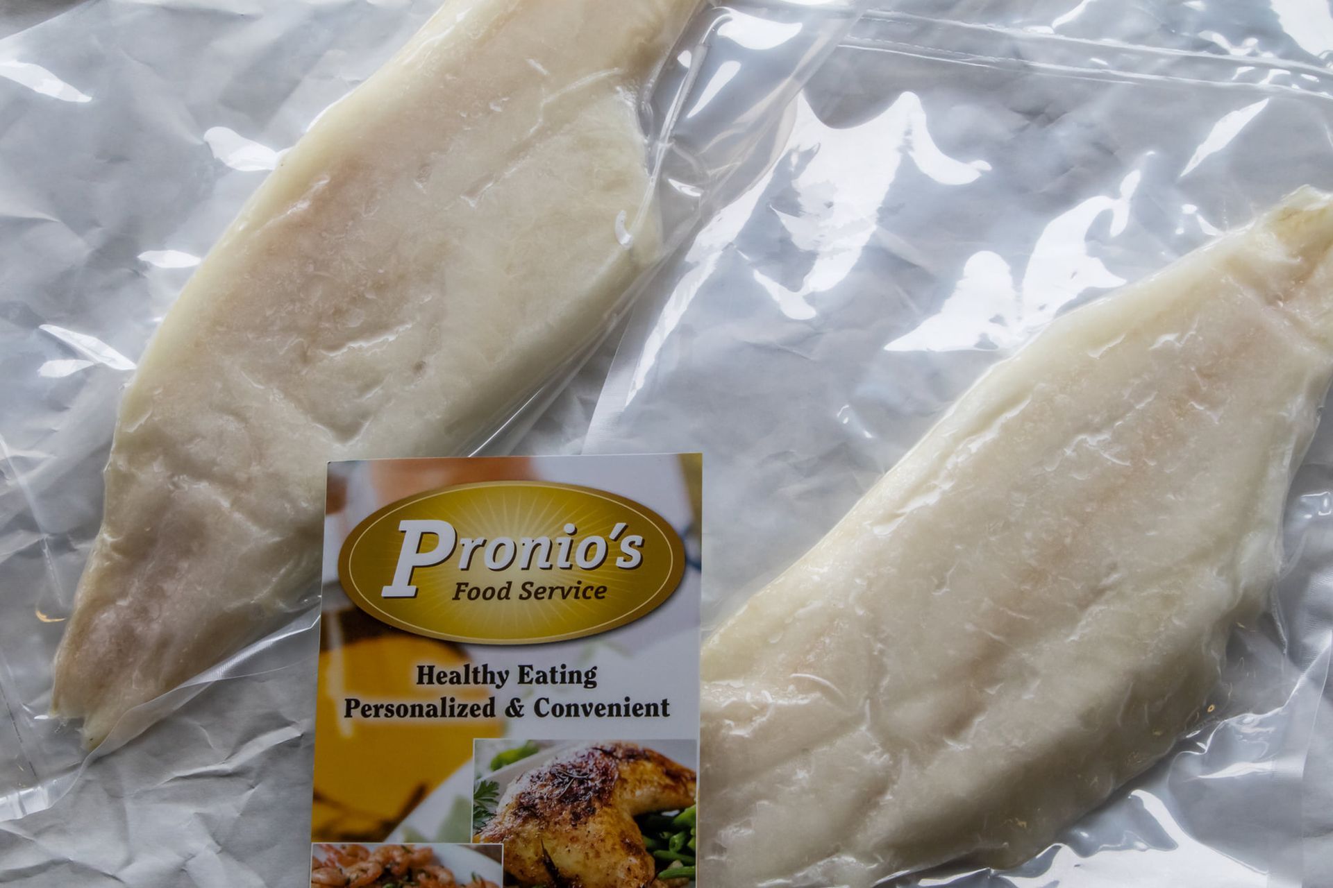 Two pieces of fish in a plastic bag from pronto 's food service