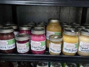 A refrigerator filled with jars of jam and juice.