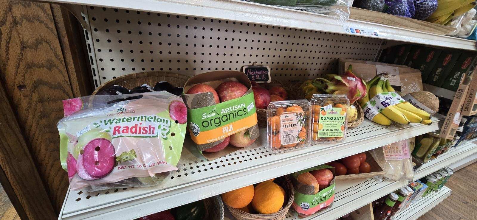 A grocery store shelf filled with fruits and vegetables.