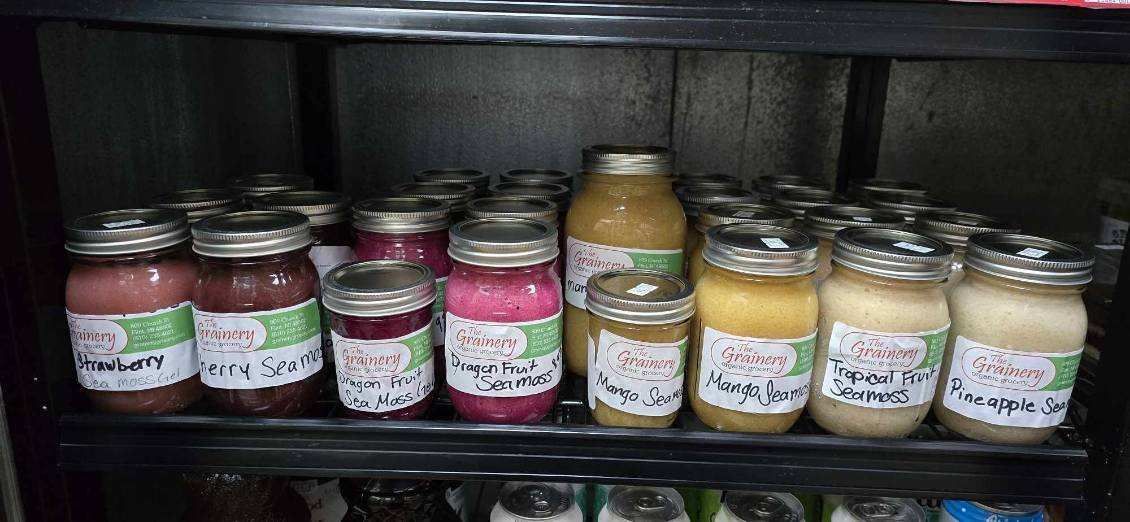 A refrigerator filled with jars of jam and juice.