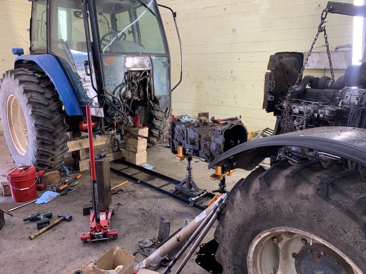 A tractor is being worked on in a garage.