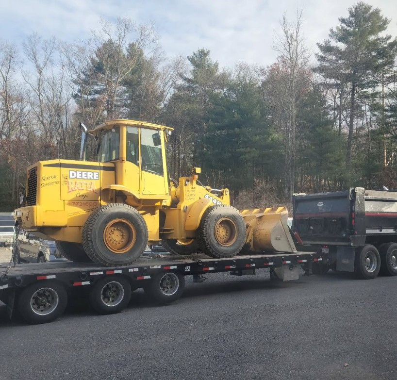 A yellow deere wheel loader is on a trailer