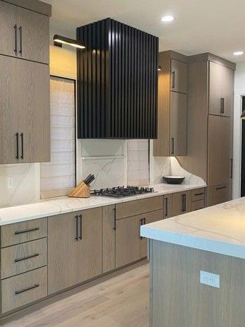 A kitchen with wooden cabinets and a stove top oven.
